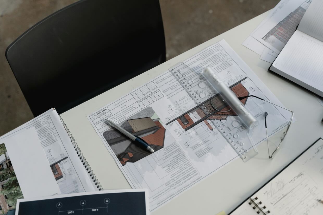 architect’s materials on desk - building plans, pen, glasses and ruler